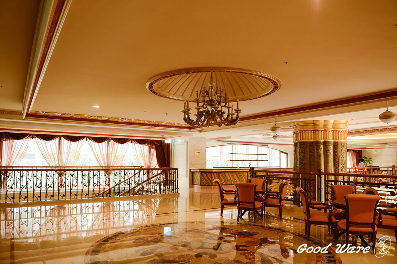 交誼廳採懸浮吊頂，外邊緣以雕花平面線板、內側則以雕花角線板包覆裝飾，吊頂面運用大型飾花與凹頂燈座，當夕陽西下、刷金的裝飾建材與鵝黃的地磚、壁面相互照映，彷彿置身於法國高級餐廳悠閒喝下午茶